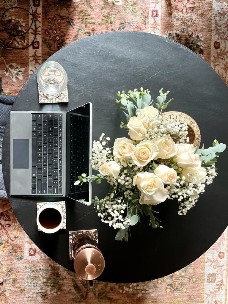 A laptop, coffee and bouquet of flowers set the tone for an article on how to switch careers.