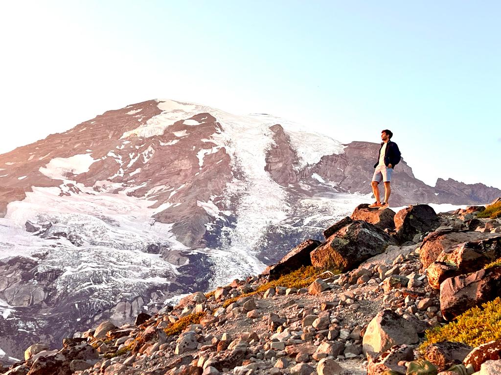 Man overlooking a mountain peak represents achievement in learning how to be more consistent